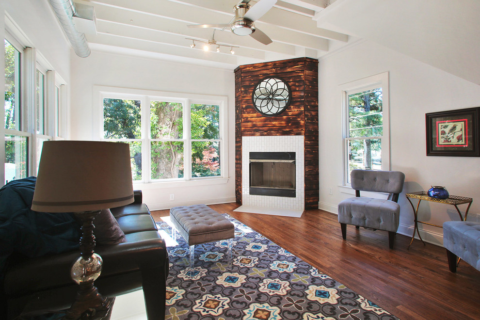 Mid-sized transitional loft-style dark wood floor family room photo in Atlanta with gray walls, a corner fireplace, a wood fireplace surround and a wall-mounted tv