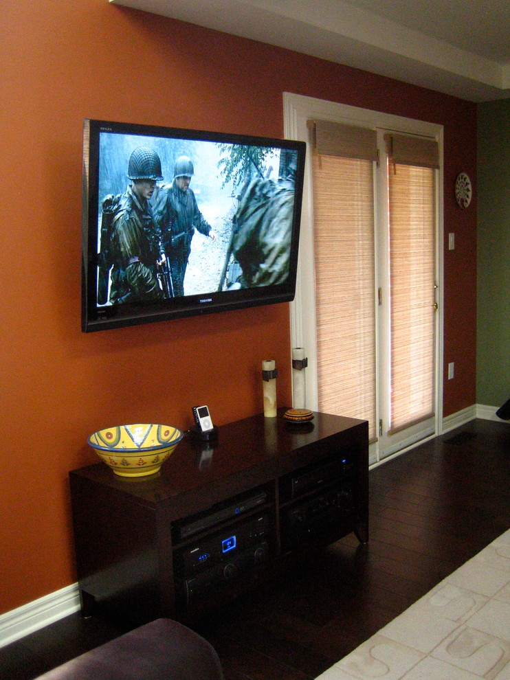 Ispirazione per un soggiorno minimal di medie dimensioni e aperto con pareti arancioni, parquet scuro e TV a parete