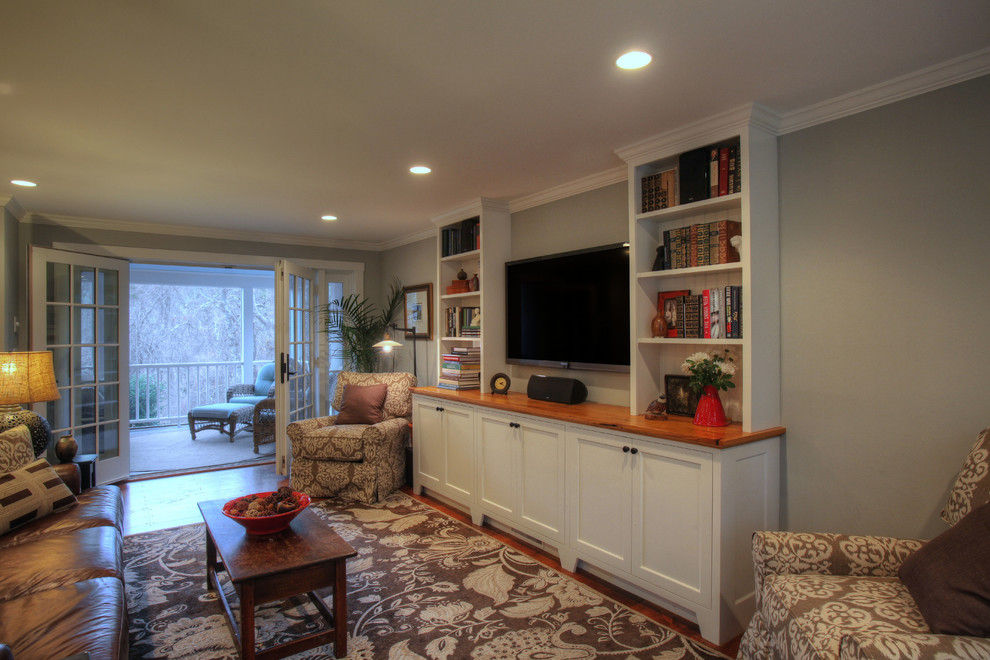 Источник вдохновения для домашнего уюта: изолированная гостиная комната среднего размера в классическом стиле с с книжными шкафами и полками, серыми стенами, паркетным полом среднего тона и телевизором на стене без камина