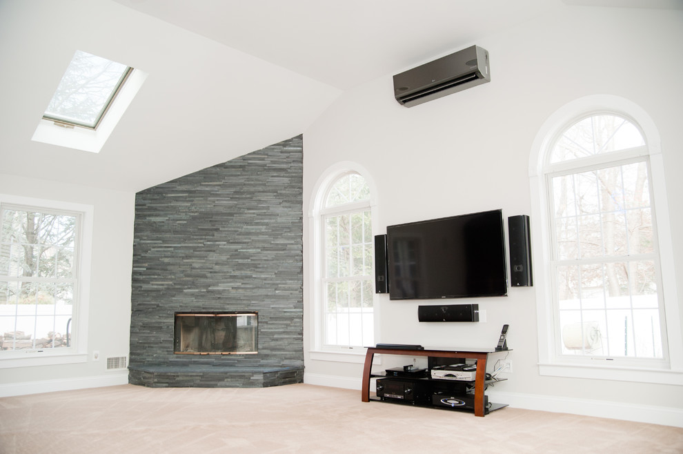 Diseño de sala de estar abierta actual grande con paredes blancas, moqueta, todas las chimeneas, marco de chimenea de piedra y televisor colgado en la pared