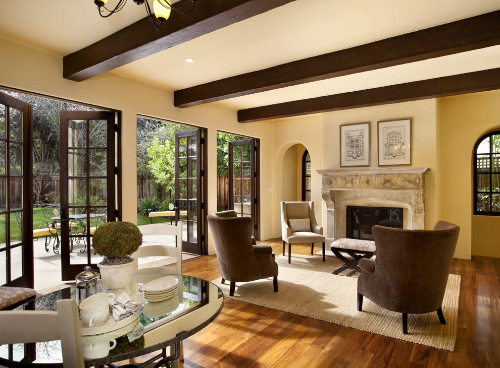 Ejemplo de sala de estar tradicional con paredes beige, suelo de madera en tonos medios, todas las chimeneas y marco de chimenea de piedra