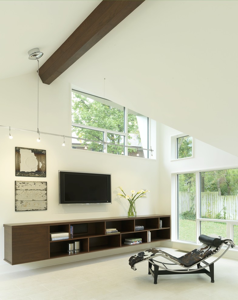 На фото: открытая гостиная комната среднего размера в современном стиле с белыми стенами, телевизором на стене и полом из известняка без камина