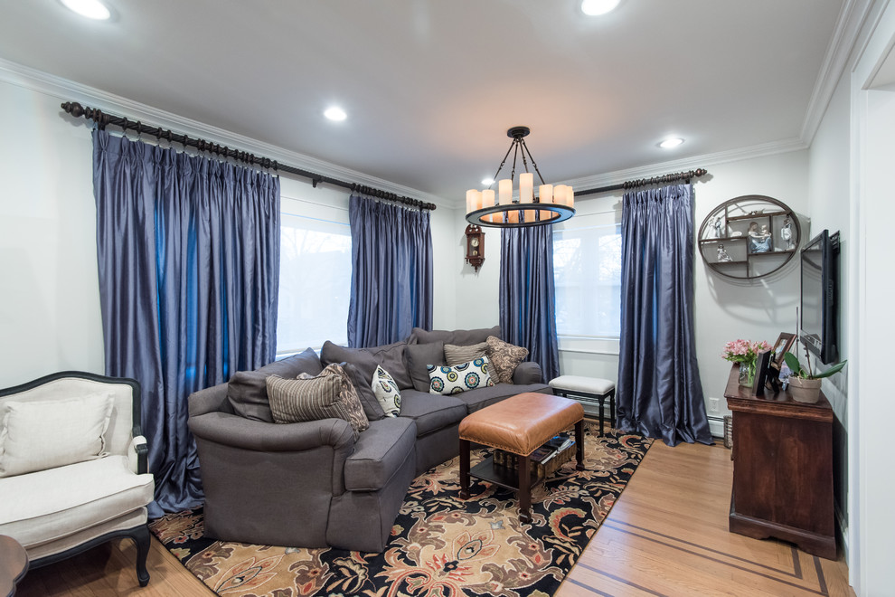 Foto de sala de estar abierta clásica renovada de tamaño medio sin chimenea con paredes blancas, suelo de madera clara y televisor colgado en la pared