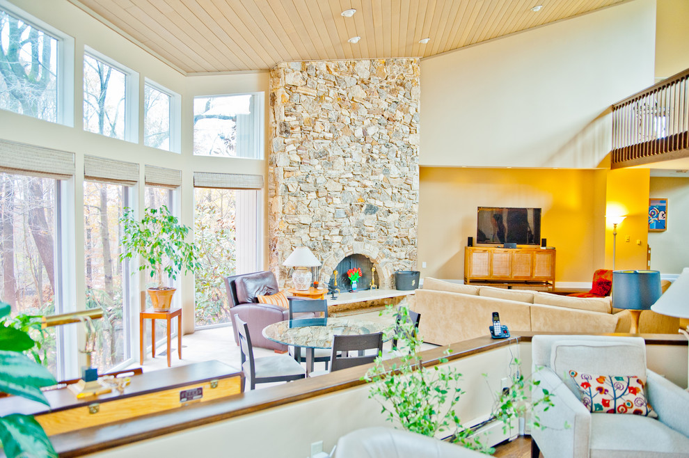 Foto di un ampio soggiorno tradizionale aperto con pareti beige, moquette, camino classico, cornice del camino in pietra e TV autoportante