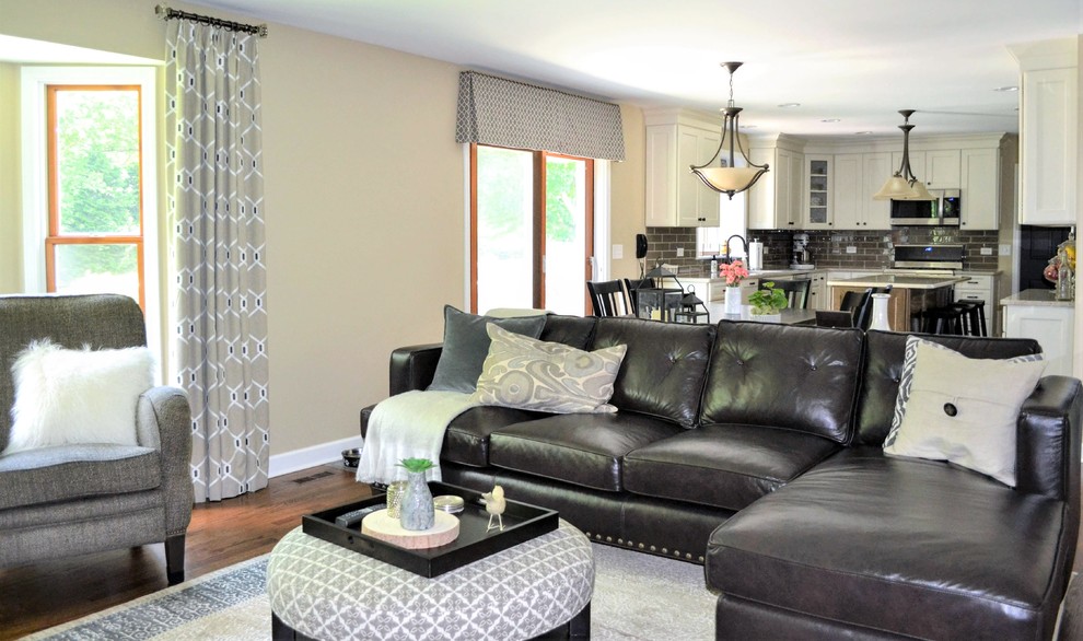Imagen de sala de estar abierta clásica renovada grande con paredes negras, suelo de madera en tonos medios y suelo marrón