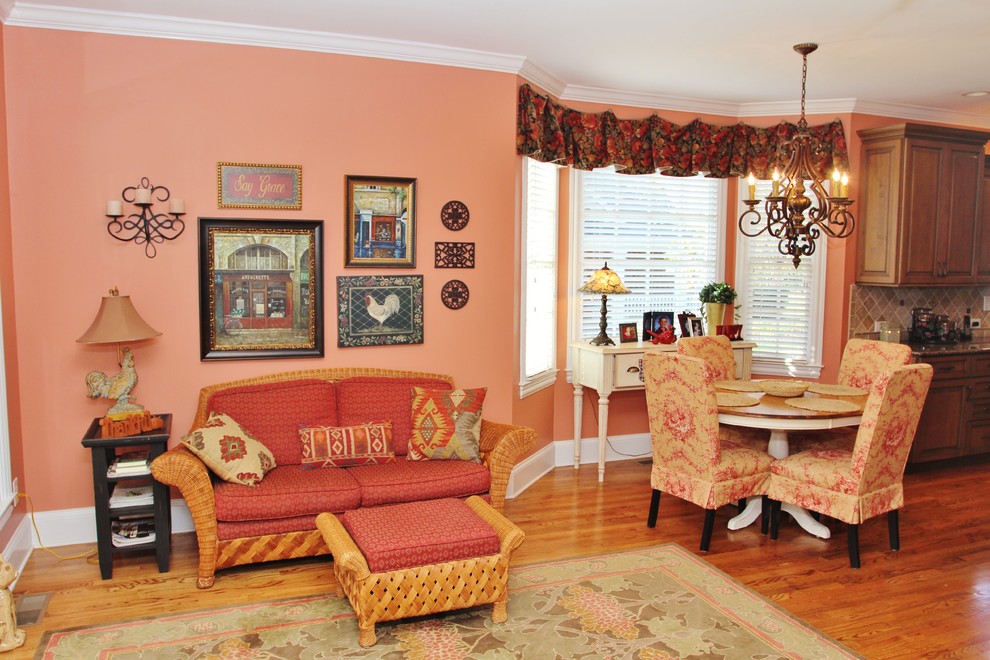 Пример оригинального дизайна: открытая гостиная комната среднего размера в классическом стиле с оранжевыми стенами, паркетным полом среднего тона, двусторонним камином, фасадом камина из камня и телевизором на стене