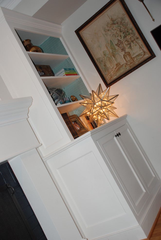 Imagen de sala de estar clásica renovada pequeña con paredes beige, suelo de madera clara, todas las chimeneas y marco de chimenea de madera