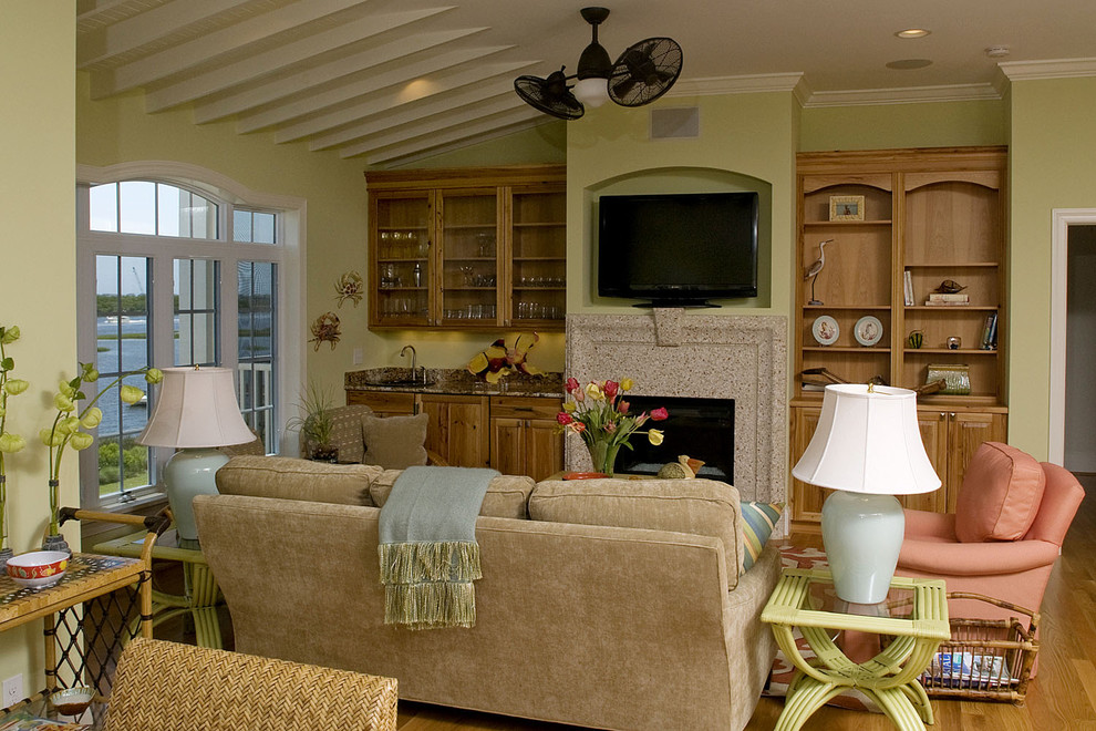 Eklektisches Wohnzimmer mit beiger Wandfarbe, braunem Holzboden, Kamin und freistehendem TV in Raleigh