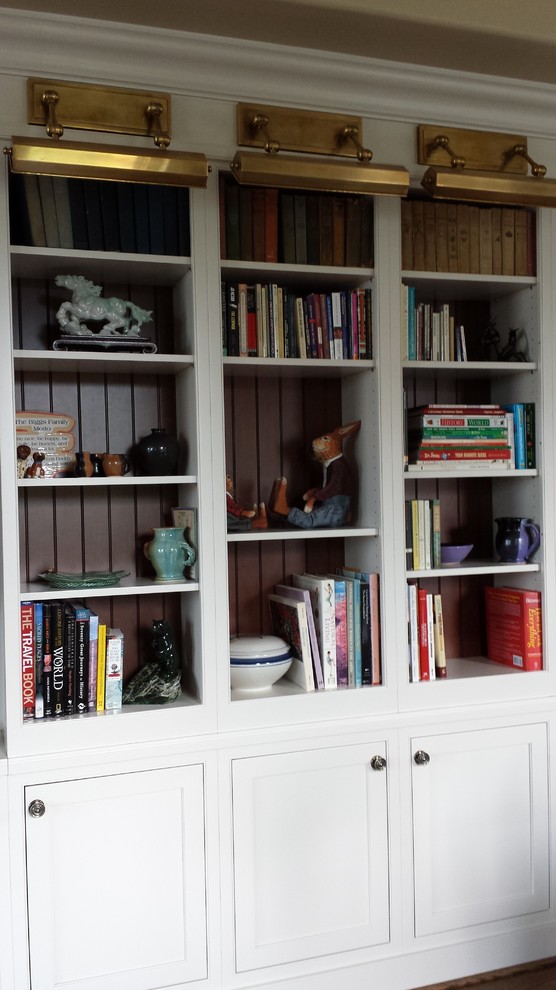 Example of a large classic family room library design in Other with a media wall