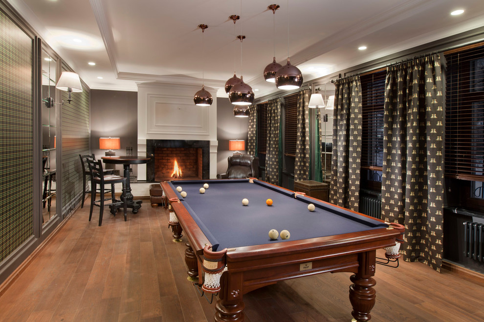 Inspiration for a medium sized traditional enclosed games room in Moscow with a standard fireplace and medium hardwood flooring.