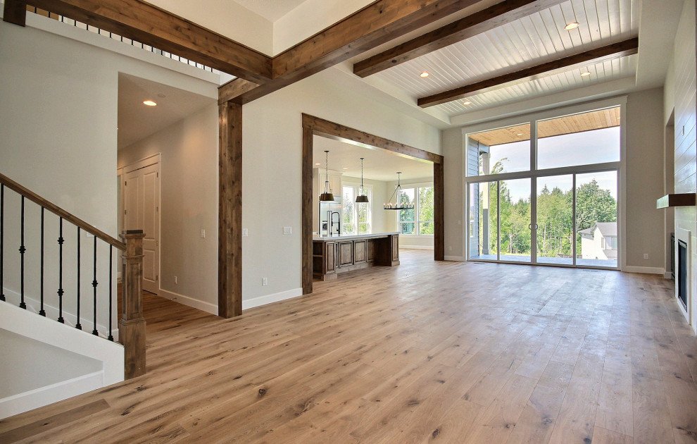Inspiration for a huge transitional open concept light wood floor, brown floor and exposed beam family room remodel in Portland with beige walls, a standard fireplace, a shiplap fireplace and a wall-mounted tv