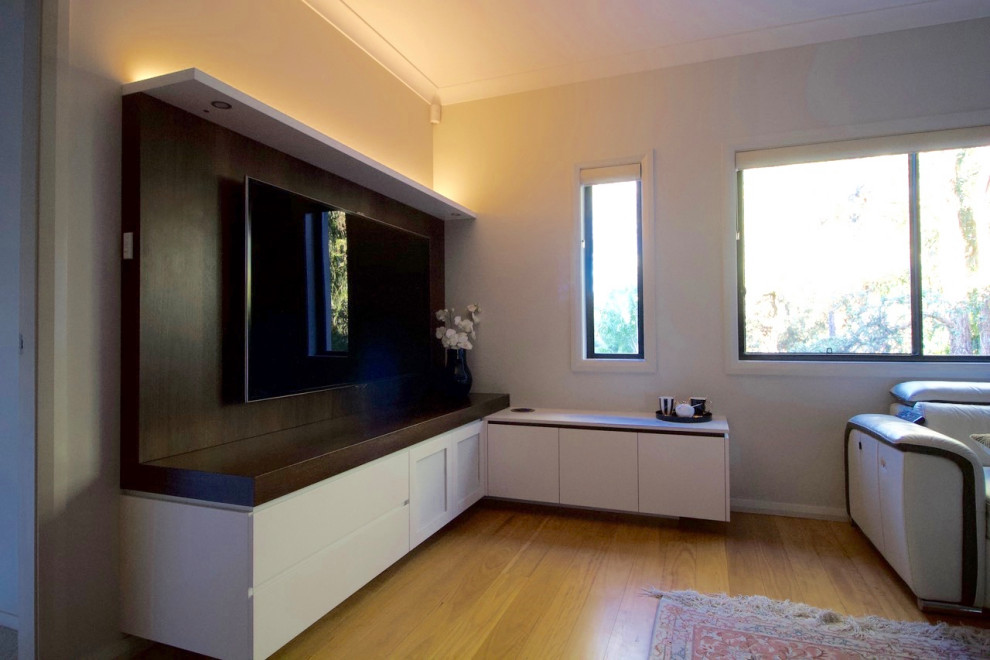 Ispirazione per un soggiorno minimal di medie dimensioni con pareti grigie, pavimento in legno massello medio, parete attrezzata e pavimento marrone