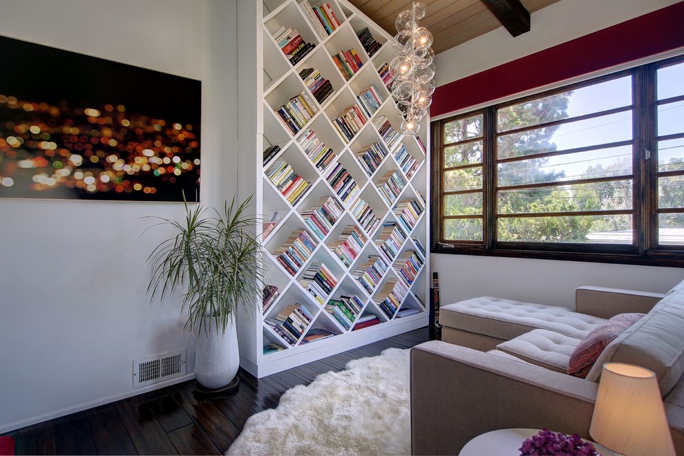 Mittelgroße, Fernseherlose Moderne Bibliothek ohne Kamin mit dunklem Holzboden und weißer Wandfarbe in Los Angeles
