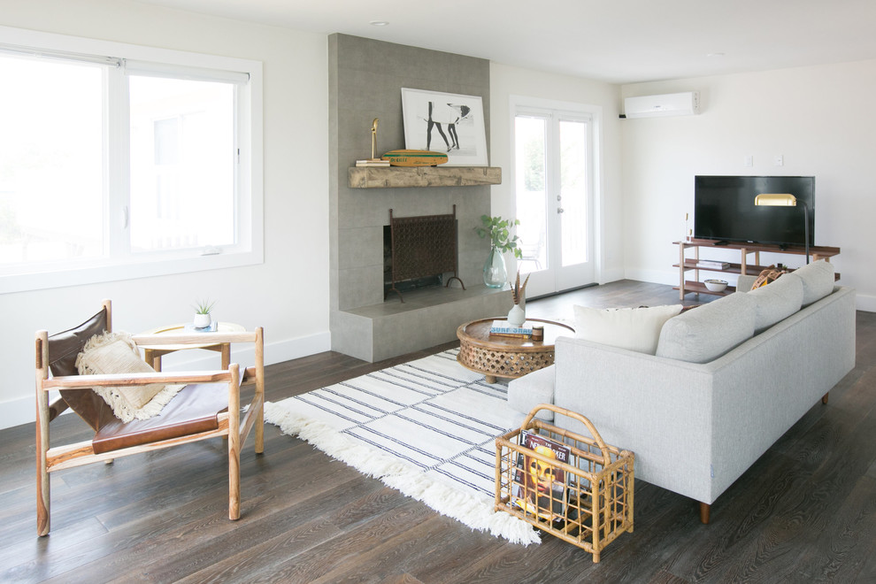 Repräsentatives, Abgetrenntes Maritimes Wohnzimmer mit weißer Wandfarbe, dunklem Holzboden, Kamin, Kaminumrandung aus Beton, freistehendem TV und braunem Boden in San Diego