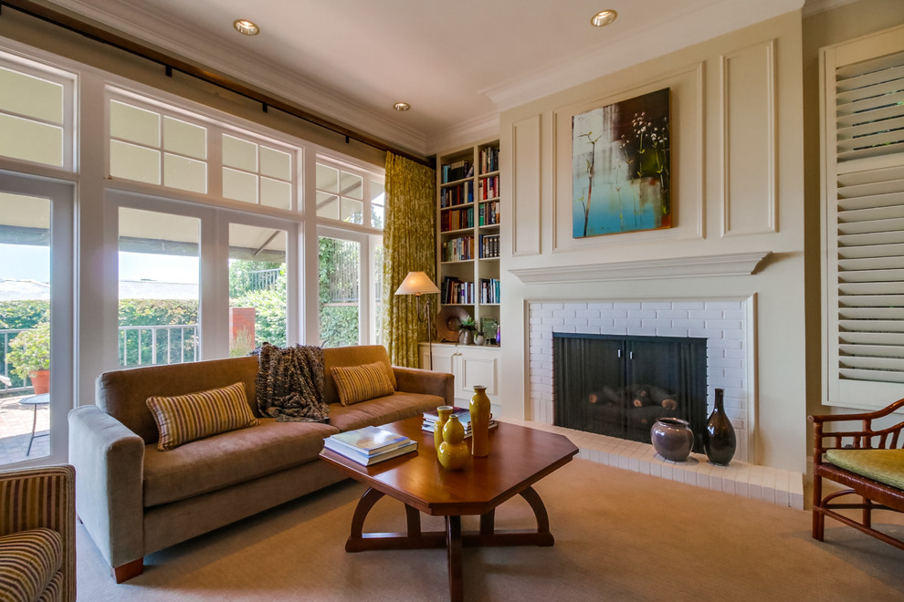 This is an example of a medium sized contemporary enclosed games room in San Diego with a reading nook, white walls, carpet, a standard fireplace, a brick fireplace surround, no tv and beige floors.