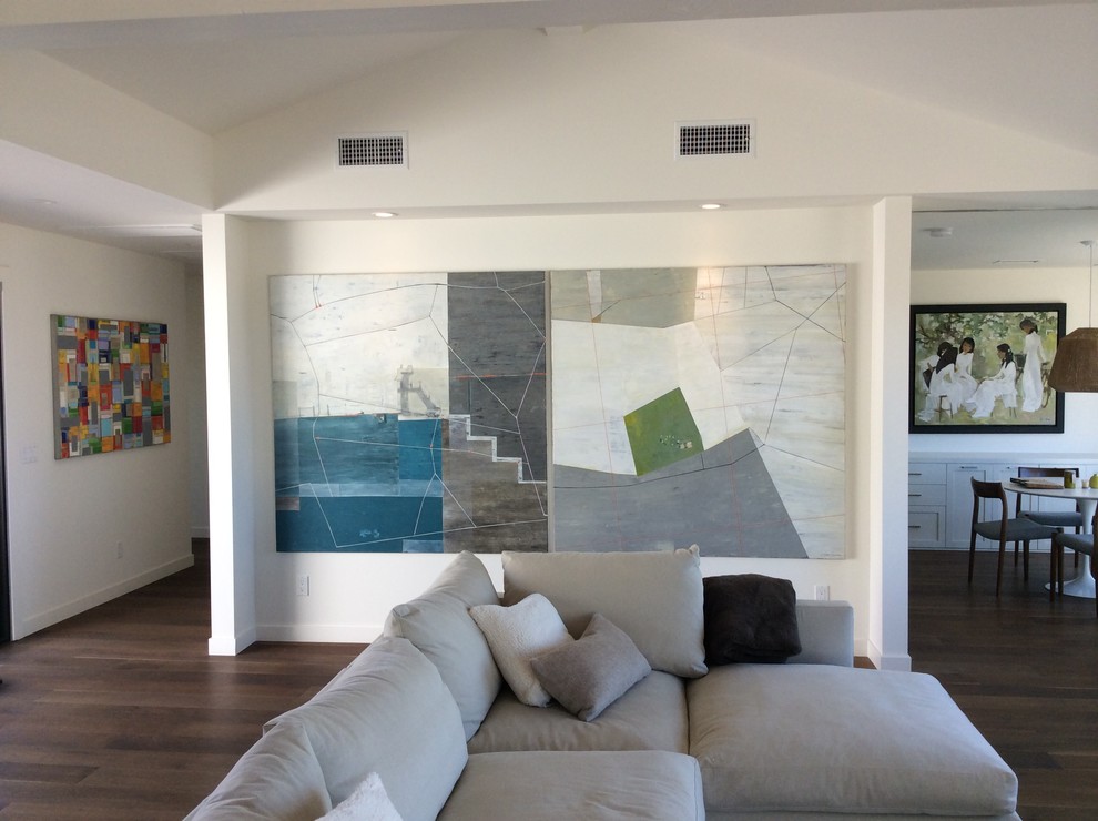 Imagen de sala de estar abierta actual grande con paredes blancas, suelo de madera oscura y suelo marrón