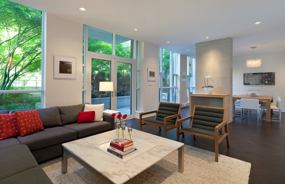 Imagen de sala de estar abierta contemporánea con paredes blancas y suelo de madera oscura