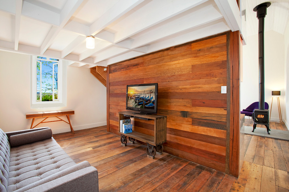 Diseño de sala de estar industrial con suelo de madera en tonos medios, televisor independiente y paredes marrones
