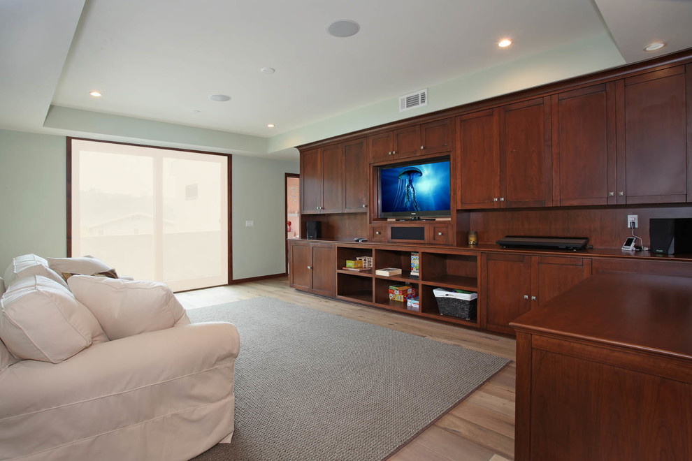 Foto de sala de estar cerrada tradicional renovada de tamaño medio sin chimenea con paredes verdes, suelo de madera clara, televisor colgado en la pared y suelo beige