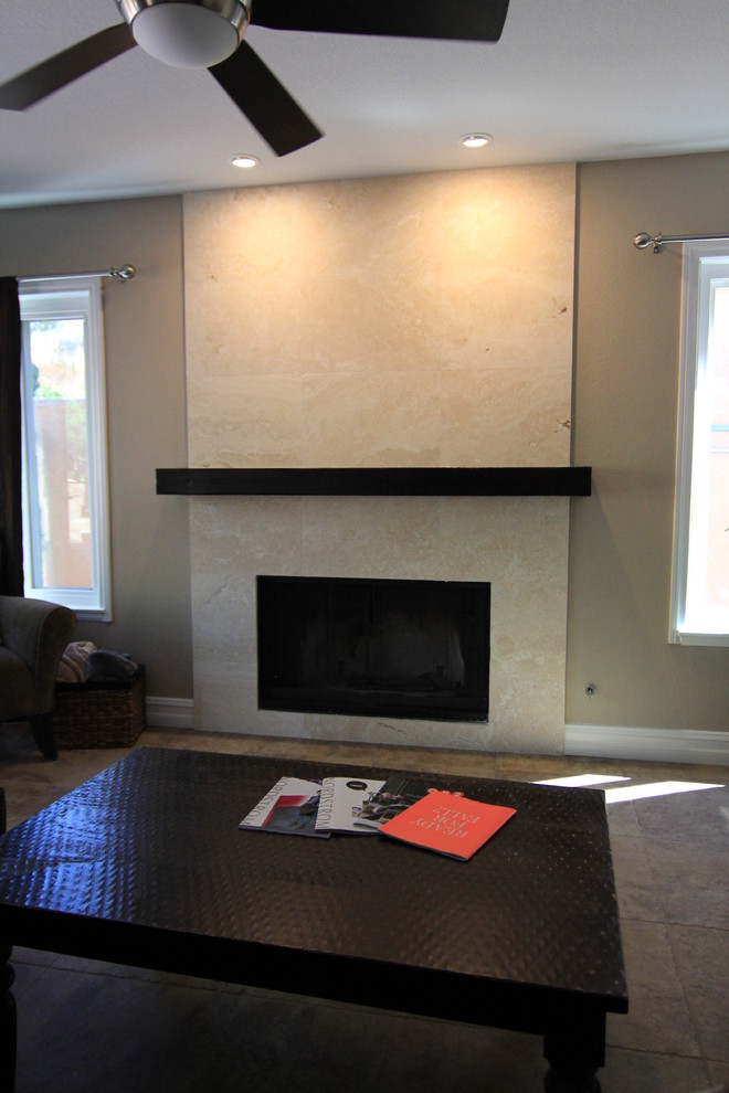 Immagine di un soggiorno minimal di medie dimensioni e aperto con pareti grigie, camino classico, cornice del camino piastrellata e TV autoportante