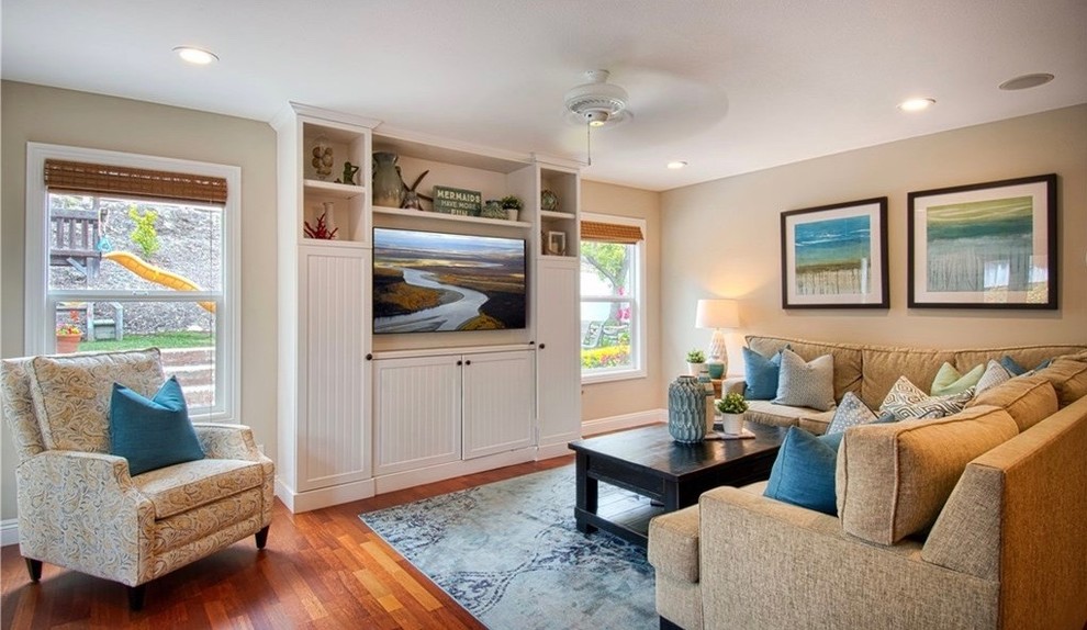 Offenes, Mittelgroßes Maritimes Wohnzimmer ohne Kamin mit beiger Wandfarbe, braunem Holzboden, Multimediawand und braunem Boden in Orange County