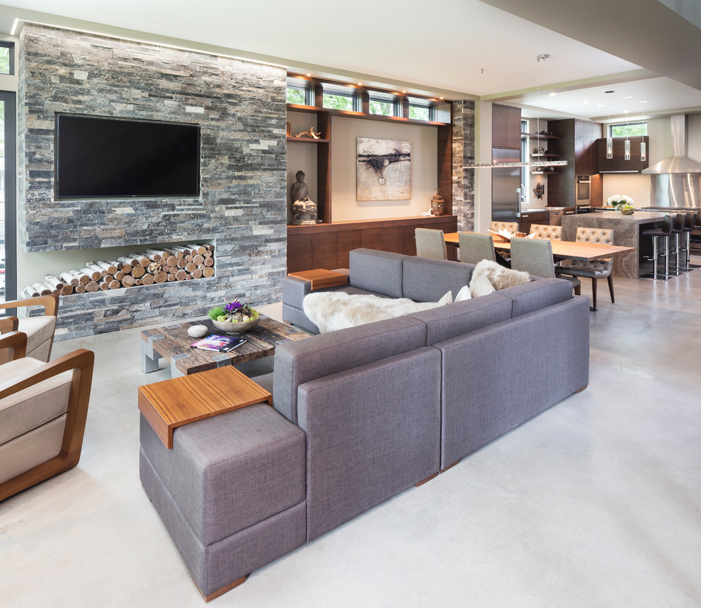 Immagine di un piccolo soggiorno moderno aperto con pareti beige, pavimento in cemento, nessun camino, cornice del camino in pietra e TV a parete