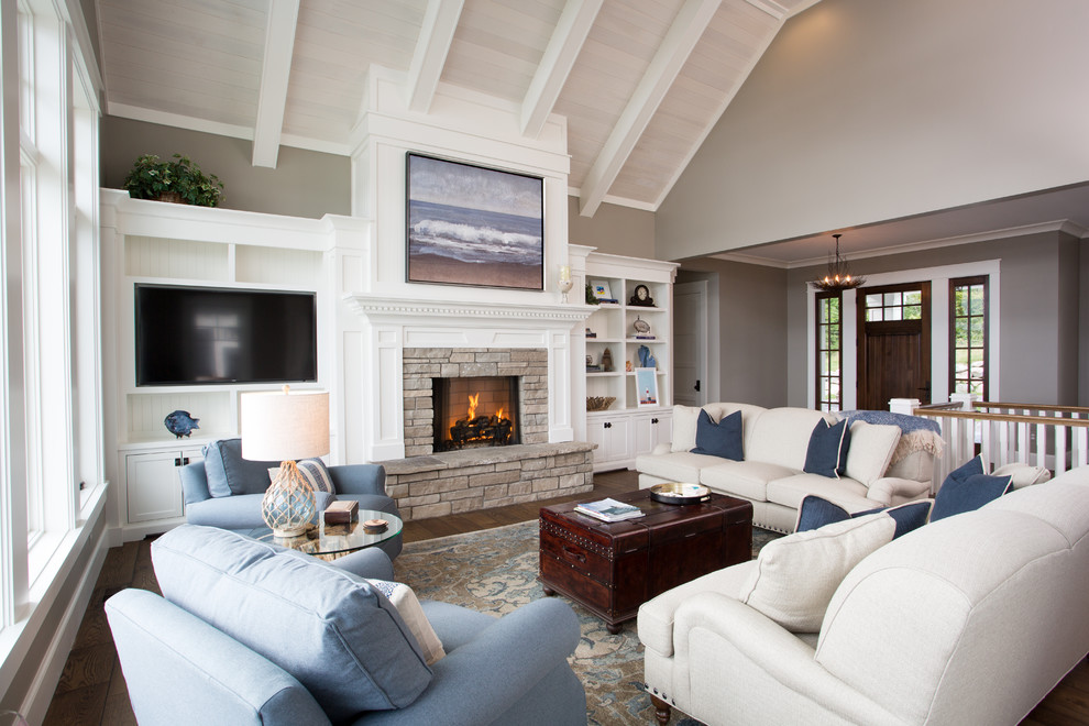 Medium sized nautical open plan games room in Other with beige walls, dark hardwood flooring, a standard fireplace, a stone fireplace surround, a wall mounted tv, brown floors and feature lighting.