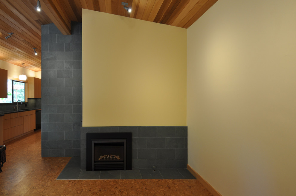 Mittelgroßer, Offener Moderner Hobbyraum mit gelber Wandfarbe, Korkboden, Kamin und gefliester Kaminumrandung in Seattle