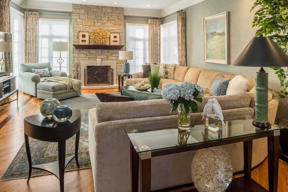 Family room - mid-sized transitional enclosed medium tone wood floor family room idea in Chicago with a standard fireplace, a stone fireplace and gray walls
