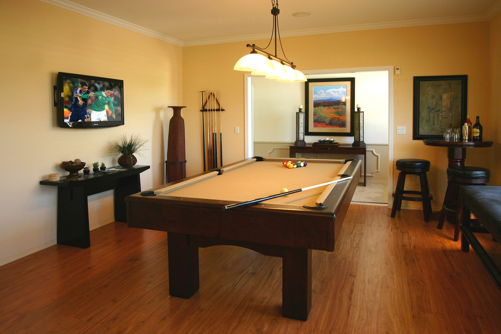 Ejemplo de sala de juegos en casa cerrada clásica renovada de tamaño medio con paredes beige, suelo de madera en tonos medios y televisor colgado en la pared