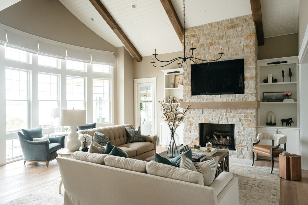 Photo of a large farmhouse enclosed games room in Detroit with beige walls, light hardwood flooring, a standard fireplace, a stone fireplace surround, a built-in media unit and brown floors.