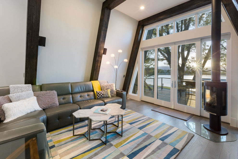 Inspiration pour une salle de séjour design ouverte avec un mur blanc et un poêle à bois.