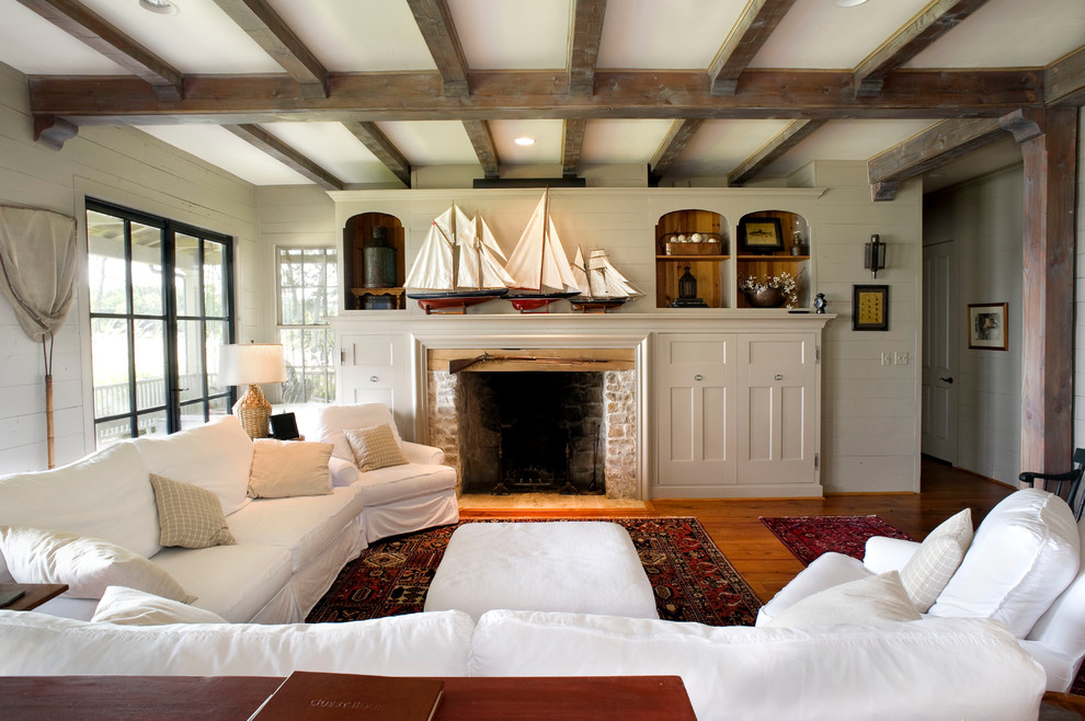 Esempio di un soggiorno stile rurale con pareti beige, pavimento in legno massello medio, camino classico e cornice del camino in mattoni