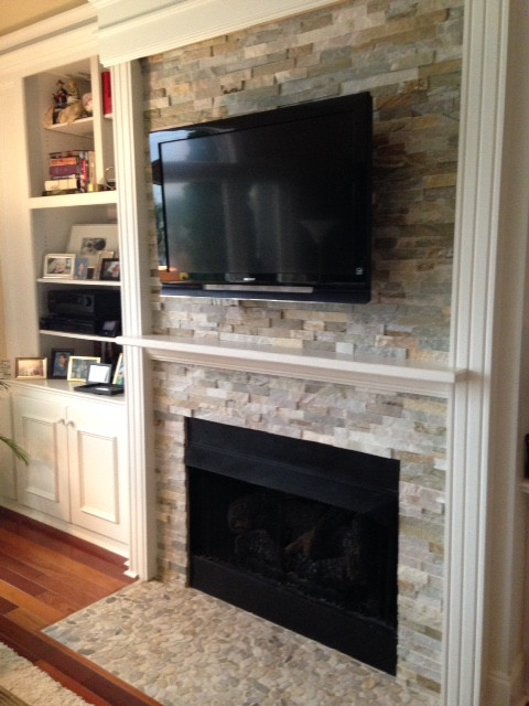 Mittelgroßes, Offenes Shabby-Style Wohnzimmer mit beiger Wandfarbe, dunklem Holzboden, Kamin, Kaminumrandung aus Stein und TV-Wand in Charlotte
