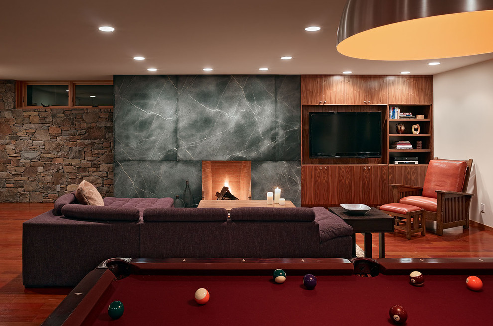 This is an example of a contemporary games room in San Francisco with a stone fireplace surround.
