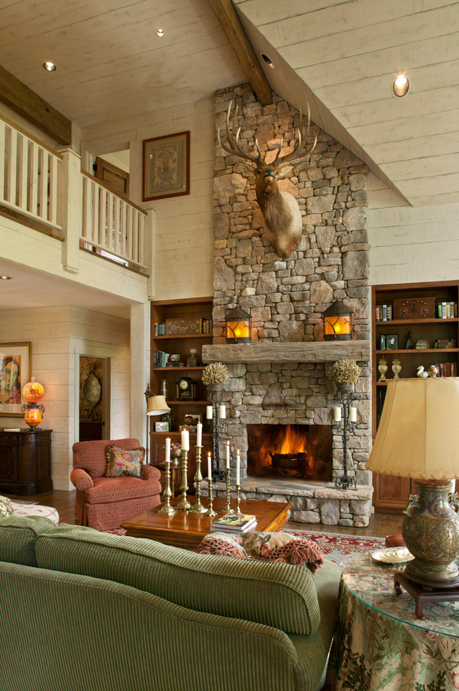 Ejemplo de sala de estar abierta clásica con paredes beige, suelo de madera oscura, todas las chimeneas y marco de chimenea de piedra