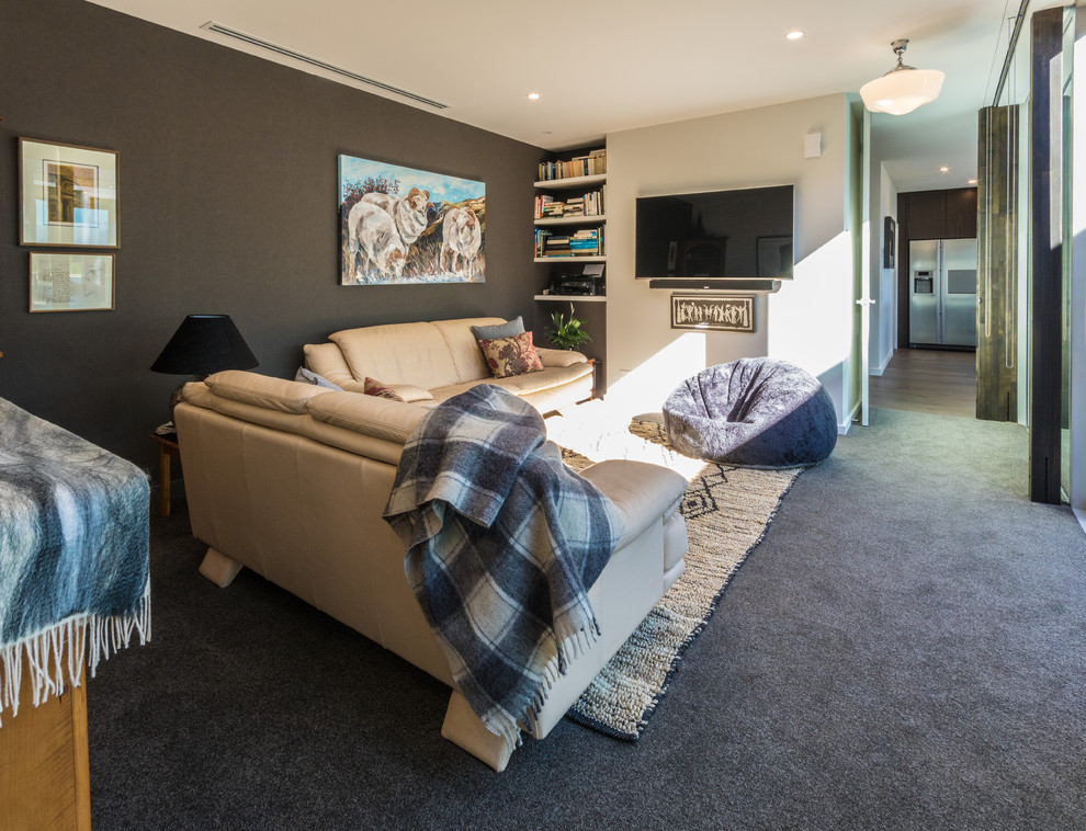 Immagine di un grande soggiorno design con moquette, TV a parete, pavimento grigio e pareti grigie