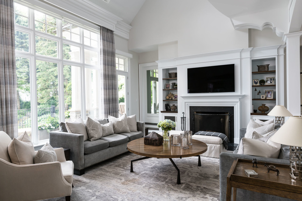 Modelo de sala de estar clásica con paredes beige, todas las chimeneas, marco de chimenea de metal y televisor colgado en la pared