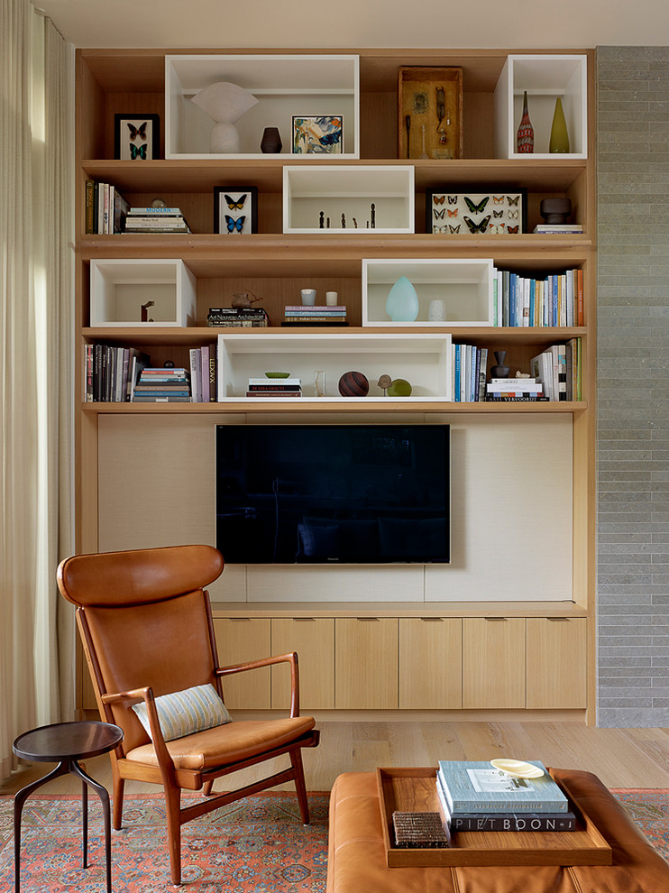 Esempio di un soggiorno moderno con parquet chiaro, TV a parete e tappeto