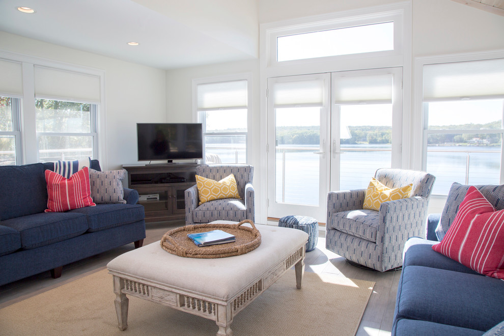 Diseño de sala de estar costera sin chimenea con paredes blancas, suelo de baldosas de porcelana y televisor independiente