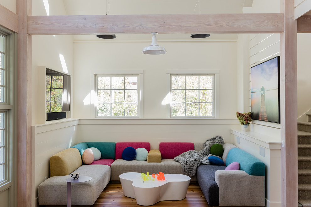 Imagen de sala de estar abierta contemporánea sin chimenea con paredes blancas, suelo de madera en tonos medios, televisor independiente y suelo marrón