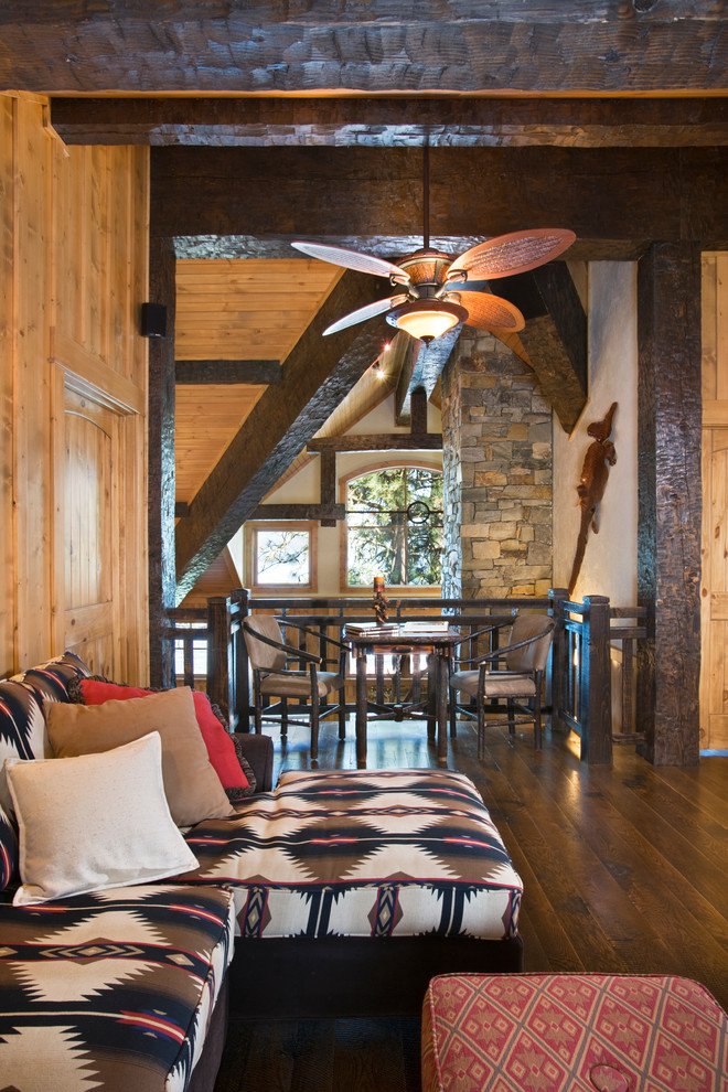 Modelo de sala de estar tipo loft rural grande con paredes marrones y suelo de madera oscura