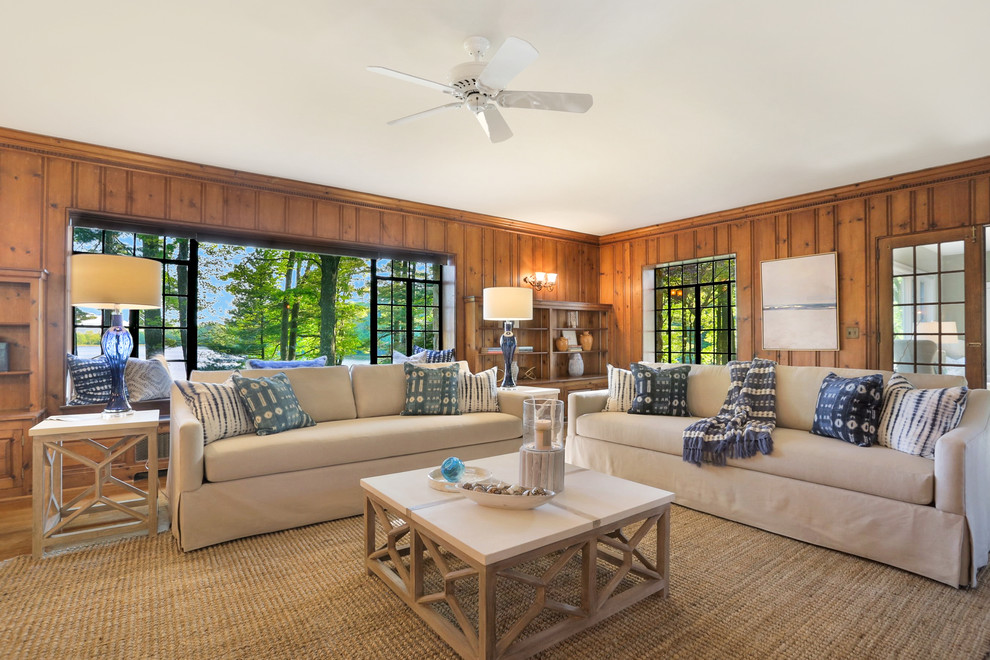 Immagine di un ampio soggiorno costiero chiuso con pavimento in legno massello medio e pareti marroni