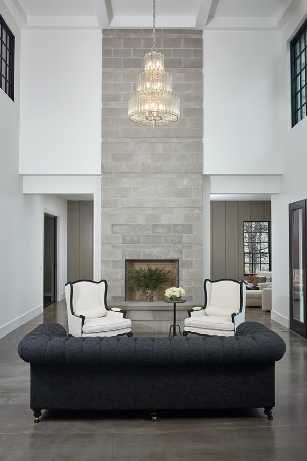 Cette photo montre un salon moderne ouvert avec un mur blanc, une cheminée standard, un manteau de cheminée en béton, un sol gris et un plafond à caissons.