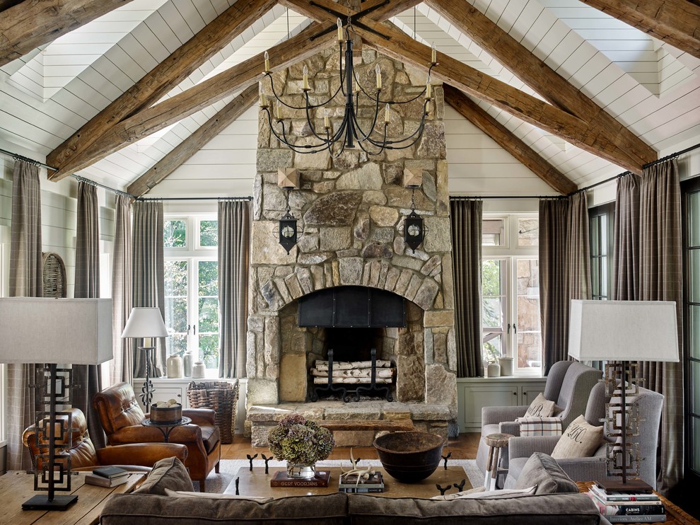 Mountain style dark wood floor and brown floor family room photo with gray walls, a standard fireplace and a stone fireplace
