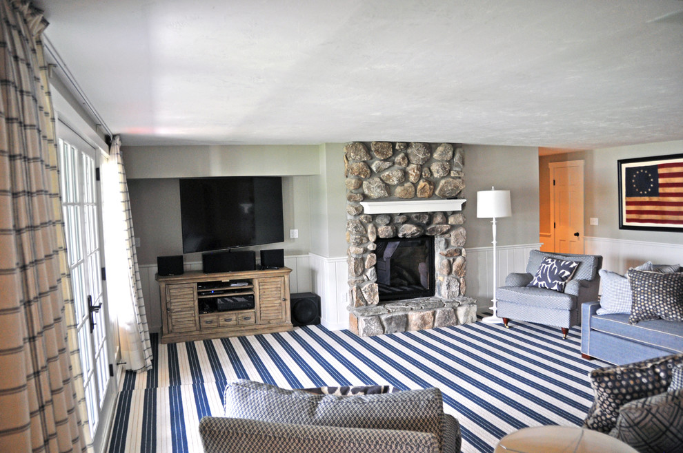 Exemple d'une grande salle de séjour chic ouverte avec salle de jeu, un mur gris, moquette, une cheminée standard, un manteau de cheminée en pierre, un téléviseur fixé au mur et un sol bleu.