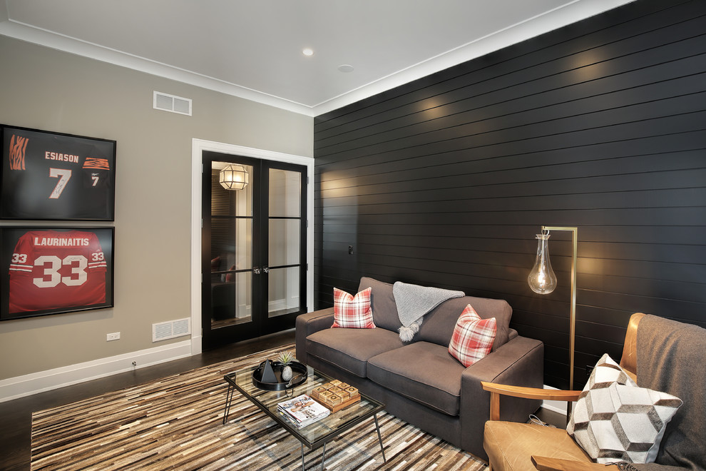 Cette image montre une grande salle de séjour traditionnelle ouverte avec un mur gris, parquet foncé, une cheminée standard, un manteau de cheminée en bois, un téléviseur encastré, un sol marron et salle de jeu.