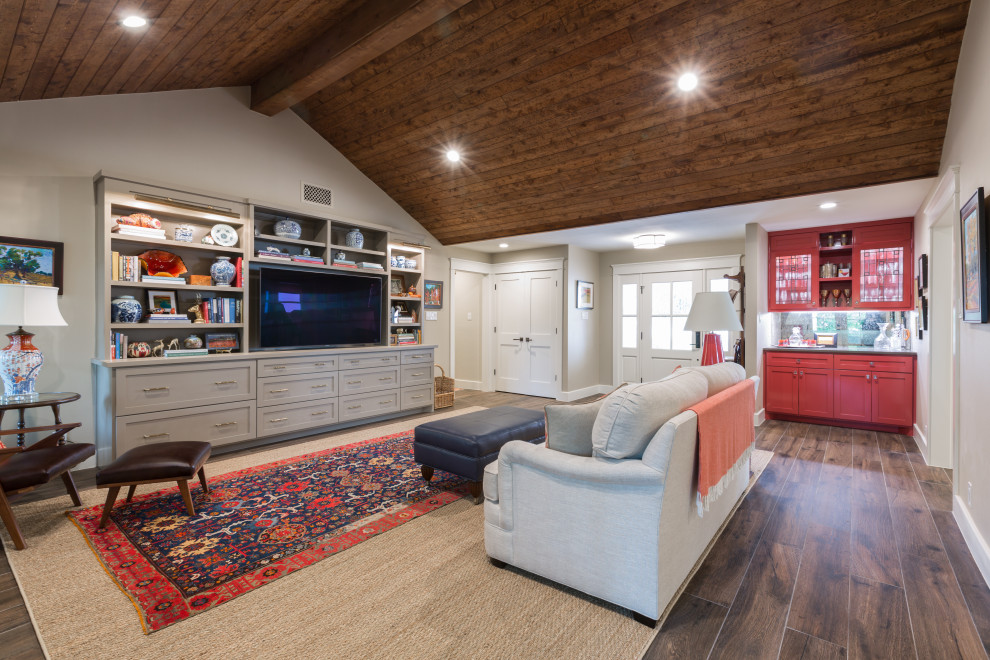 Offenes Klassisches Wohnzimmer mit beiger Wandfarbe, dunklem Holzboden, Multimediawand, braunem Boden, gewölbter Decke und Holzdecke in Austin