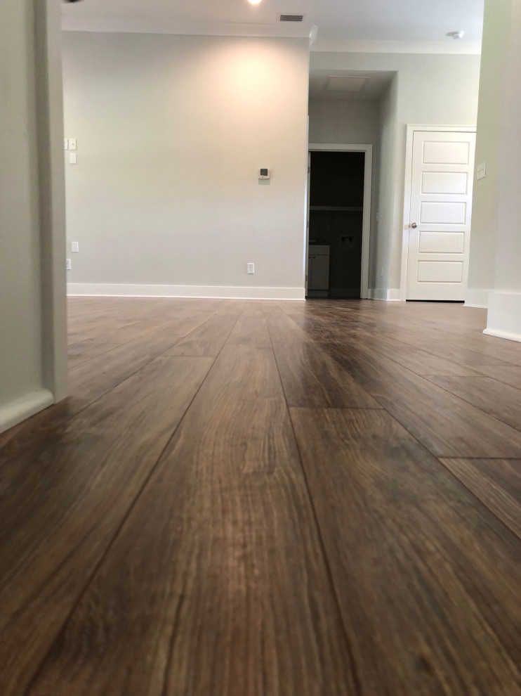 Ejemplo de sala de estar abierta tradicional renovada de tamaño medio con suelo laminado y suelo marrón