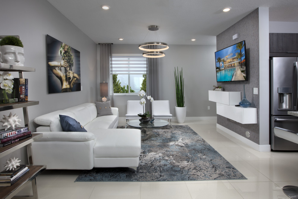 This is an example of a large modern open plan games room in Miami with grey walls, porcelain flooring, a wall mounted tv and beige floors.